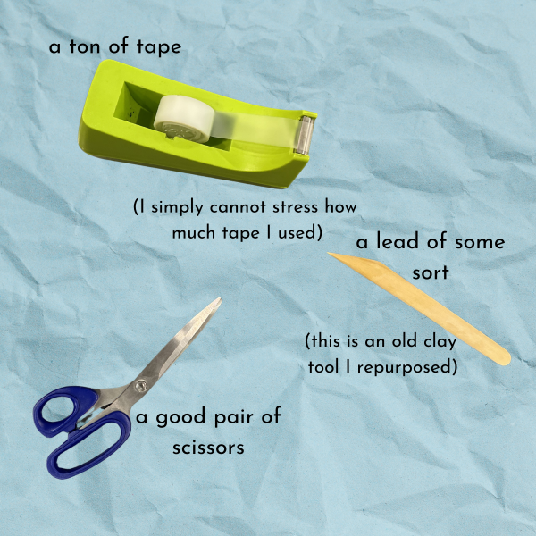 Blue paper texture background with green tape dispenser, wooden clay tool, and blue scissors, text reading "a ton of tape (I simply cannot stress how much tape I used), a lead of some sort (this is an old clay tool I repurposed), a good pair of scissors"