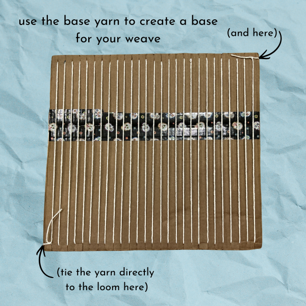 Blue paper texture background with cardboard loom with white yarn in columns, text reads "use the base yarn to create a base for your weave (tie the yarn directly to the loom here (and here))"